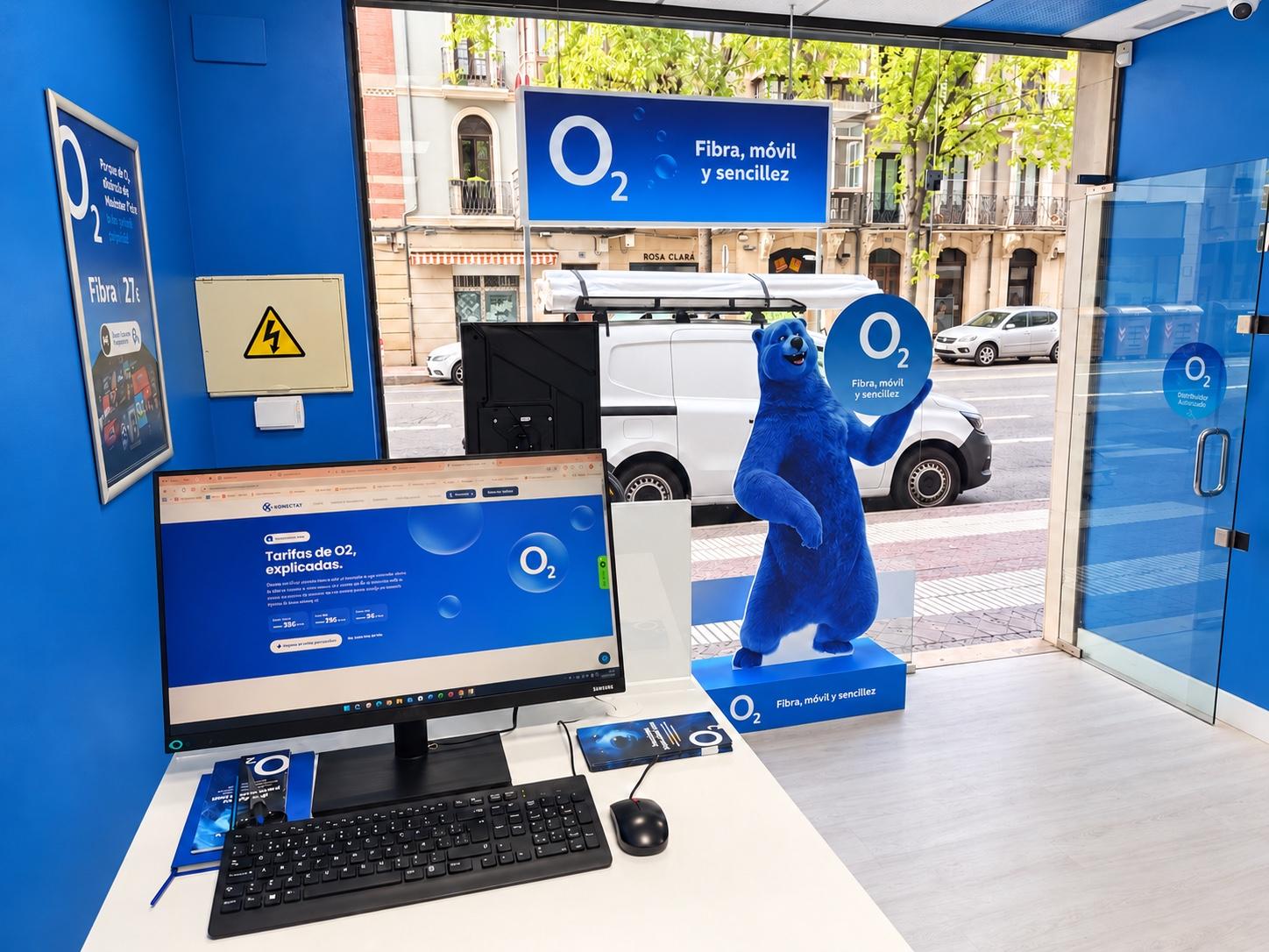 Mostrador de la tienda Konectat en C. Gral. Vara de Rey, 29, Logroño: pantalla con las tarifas de O2, el oso azul de O2 junto al escaparate y la calle al fondo